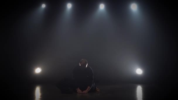 Kendo instructor is bowing sitting at dark studio. Slow motion. — Stock Video