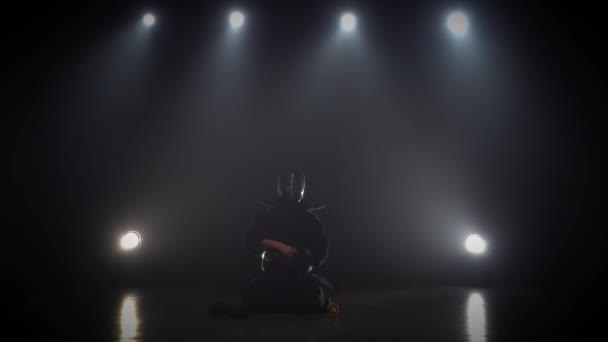 Kendo-Meister trägt eine Rüstung im dunklen Studio. Zeitlupe — Stockvideo