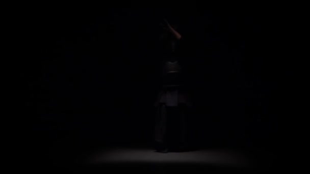 Kendo savaşçı spot altında karanlık stüdyoda Katana kılıç ile dövüş sanatı yapıyor. Yavaş çekim — Stok video