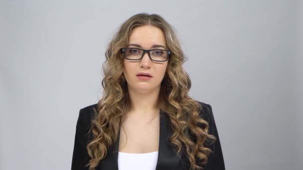 Nainen yrityspuvussa on järkyttynyt ja väsynyt, riisuu silmälasinsa — kuvapankkivideo