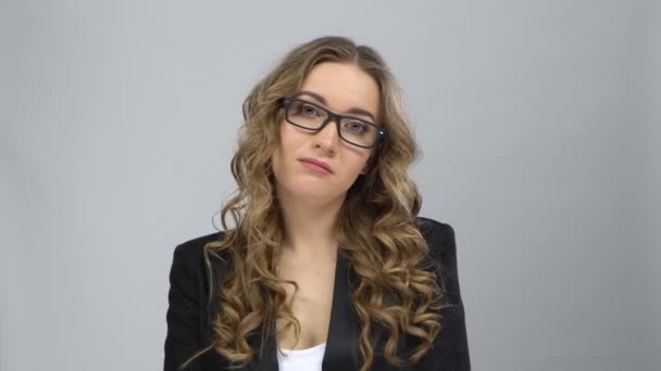 Bussines woman in glasses stands in expectation at grey background — Stock Video