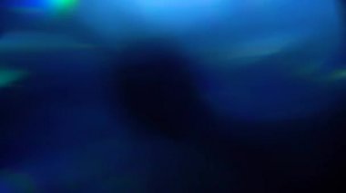 Renkli Işık darbeleri ve parıltıları. Koyu arka planda güzel ışık sızıntısı. Gerçek lens, soyut hareket arka planı için mükemmel bir parlamadır. Rüya gibi bokeh. Mavi ışık.