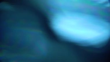 Renkli Işık darbeleri ve parıltıları. Koyu arka planda güzel ışık sızıntısı. Gerçek lens, soyut hareket arka planı için mükemmel bir parlamadır. Rüya gibi bokeh. Mavi ışık.