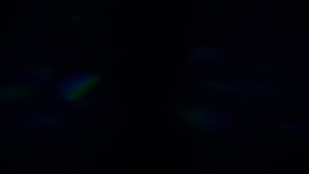 カラフルな光のパルスと輝き。暗い背景に美しい光漏れ。抽象的な動きの背景に最適な本物のレンズフレア。ドリーミー・ボケ青色光. — ストック動画