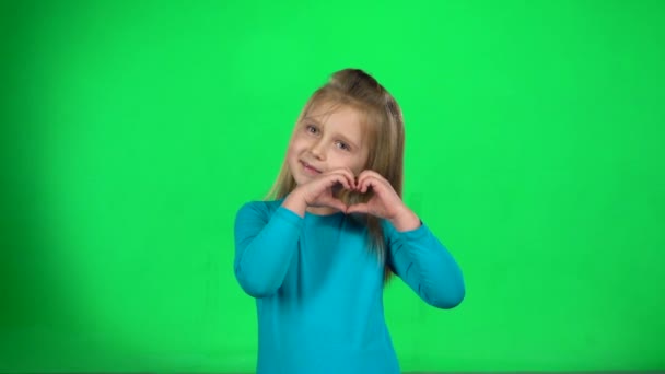 Blond meisje toont handen van het hart dan het maken van lucht kus. Slow Motion — Stockvideo