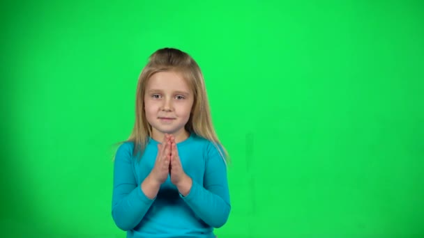 Liten flicka klappar händerna på grön bakgrund. Slow motion — Stockvideo