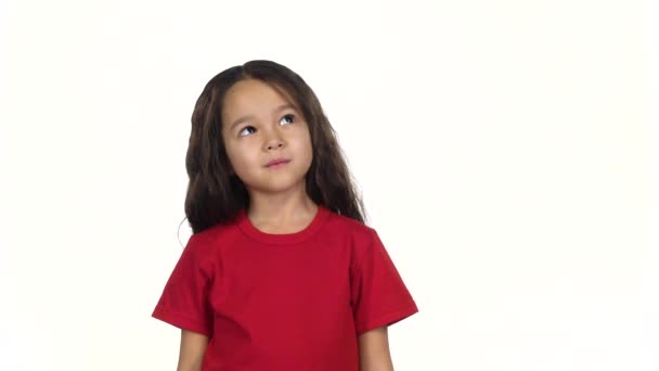 Retrato de menina posando e pensando em algo no fundo branco. Movimento lento — Vídeo de Stock