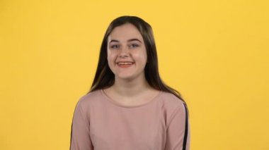 Portre genç sarı arka plan üzerinde eğlenceli poz. Yavaş çekim