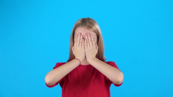Lilla kvinnliga täcker hennes ansikte med händerna och sedan titta med förvåning. Slow motion — Stockvideo