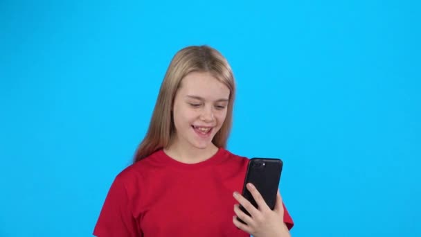 Mooi meisje het houden van een telefoon en spreken met iemand met behulp van video bellen. Slow Motion — Stockvideo