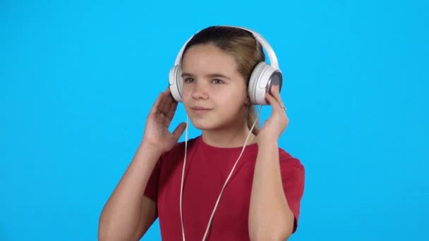 Hermoso niño escuchando música en los auriculares. Movimiento lento — Vídeo de stock