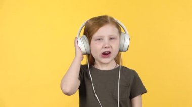 Bebek büyük beyaz kulaklıklar, şarkı ve dans müzik dinlerken. Yavaş çekim
