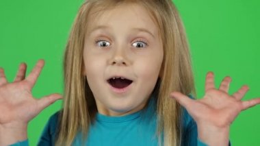 Yakın çekim çocuk pozyeşil arka plan üzerinde korkmuş duygu gösterir. Yavaş çekim