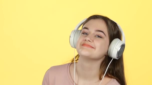 Primer plano adolescente escuchar música y bailar en los auriculares. Movimiento lento — Vídeo de stock