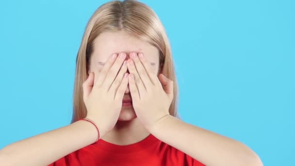 Close-up kleine vrouw bedekt haar gezicht met handen en kijkt dan met verrassing. Slow Motion — Stockvideo