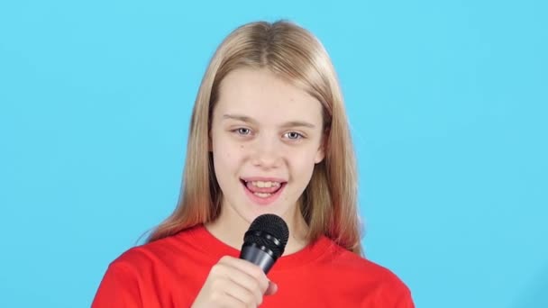 Close-up klein meisje die glimlacht en zingt met microfoon. Slow Motion — Stockvideo