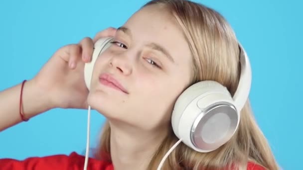Nahaufnahme hübsches Mädchen, das Musik über Kopfhörer hört. Zeitlupe — Stockvideo