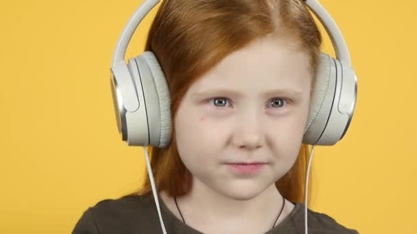 Primer plano bebé escuchando música en auriculares grandes, cámara lenta — Vídeos de Stock