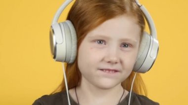 Büyük kulaklıklarla müzik keyfi ve dans eden yakın çekim bebek, yavaş çekim