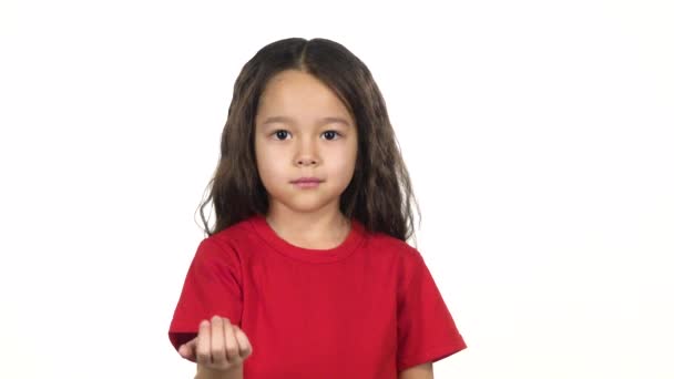 Vor weißem Hintergrund winkt die kleine Frau mit der Hand vor sich hin. Zeitlupe — Stockvideo