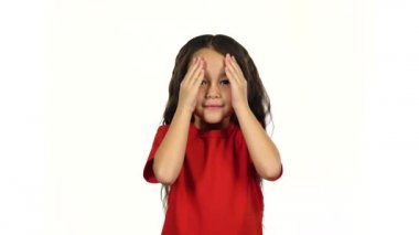 Liittle güzel kız gülümseme, eğlenmek ve elleri ile yüzünü kapsar