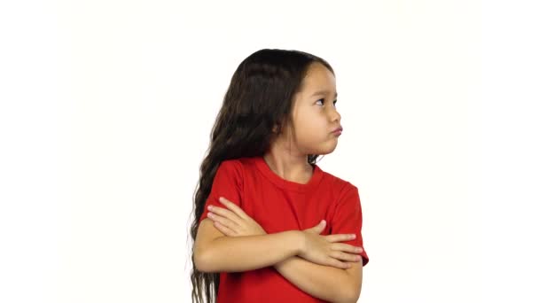 Retrato de niña muestra emoción, cruza las manos posando sobre fondo blanco — Vídeo de stock