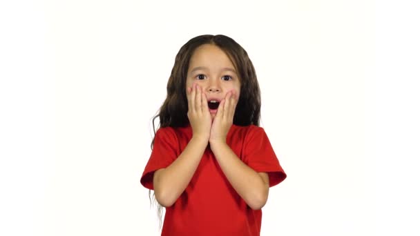 Criança posando surpreendentemente no fundo branco. 4k — Vídeo de Stock