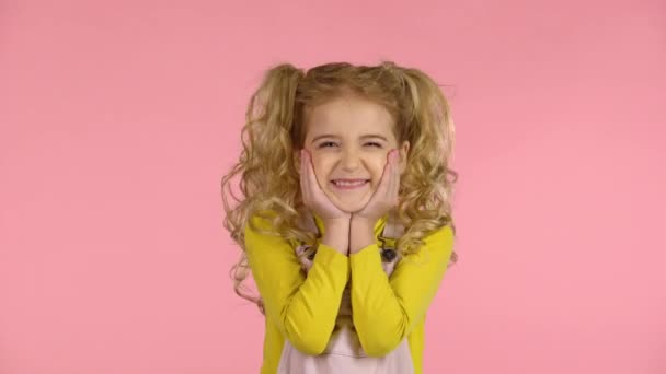 Мила неслухняна дівчина показує язик і робить обличчя — стокове відео