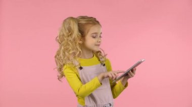 Pretty küçük kadın çocuk tablet ile oynuyor ve bir darbe öpücük gönderiyor.