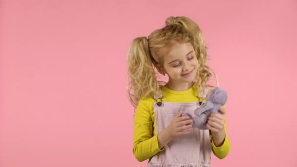 かわいいブロンドの女の子は彼女のテディベアを抱きしめている — ストック動画