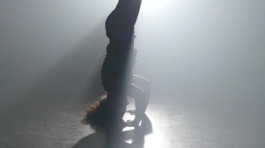 Kıvırcık bakire stüdyoda spot ışığı capoeira pratik. Yakın çekim yavaş çekim.