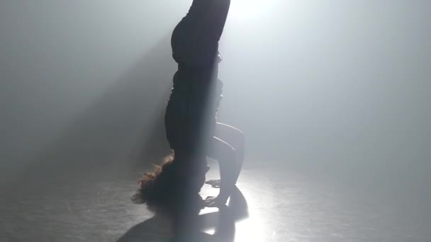 Curly Maiden praktiserande Capoeira i Ray av Spotlight i studion. Närbild slow motion. — Stockvideo