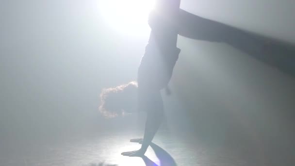 Close-up slow motion. Curly Maiden het beoefenen van capoeira in Ray of Spotlight in Studio. — Stockvideo