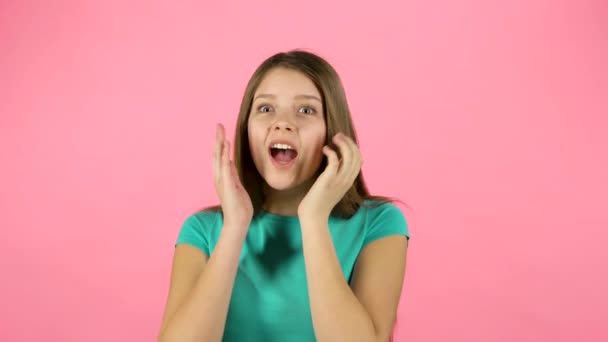 Liten kvinna är förvånad och klappar händerna på rosa bakgrund. — Stockvideo