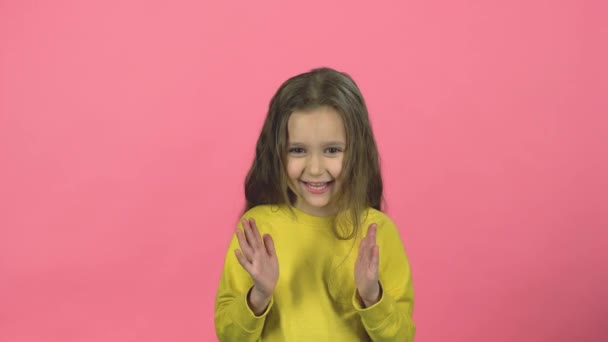Criança encantadora com sorriso está batendo palmas em fundo rosa — Vídeo de Stock