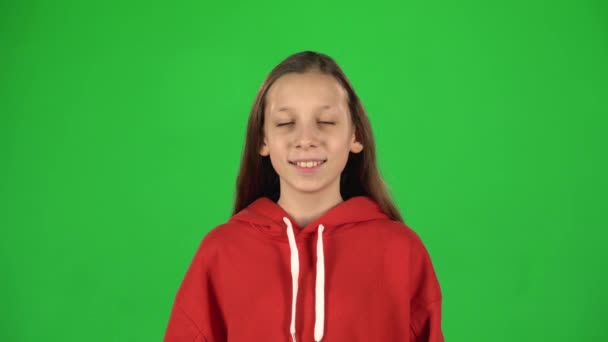 Retrato de niña sonriendo mirando a la cámara sobre fondo verde . — Vídeo de stock