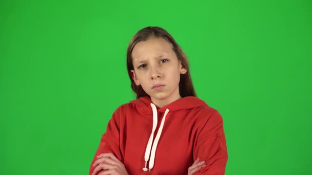 Little woman is angry and unsatisfied standing with hands at her hips on green background. — Stock Video