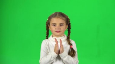 Güzel kız yeşil arka plan üzerinde ellerini çırpıyor