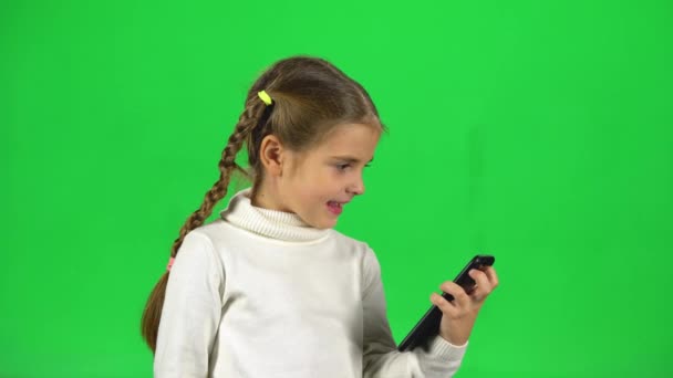 Niño hablando en el video chat en el teléfono en el estudio contra la pantalla verde — Vídeos de Stock