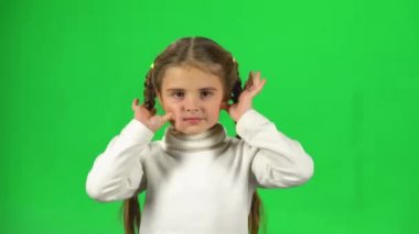 Çocuk oynarken ve stüdyoda yeşil ekranda komik yüz yapmak