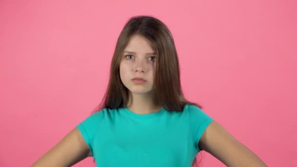 Kleine vrouw is boos en ontevreden over roze achtergrond. Slow Motion — Stockvideo