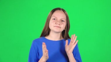 Küçük dişi ellerini çırpıyor ve sonra başparmaklarını yukarı doğru gösteriyor. Greenscreen. Yavaş çekim