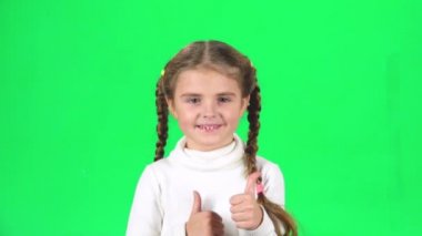 Çocuk ellerini çırpıyor ve sonra başparmaklarını yukarı gösteriyor. Greenscreen. Yavaş çekim