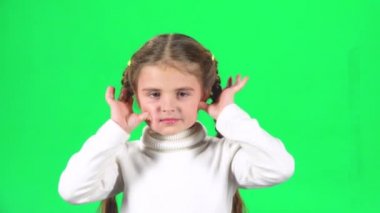 Çocuk oynarken ve stüdyoda yeşil ekranda komik yüz yapmak. Yavaş çekim