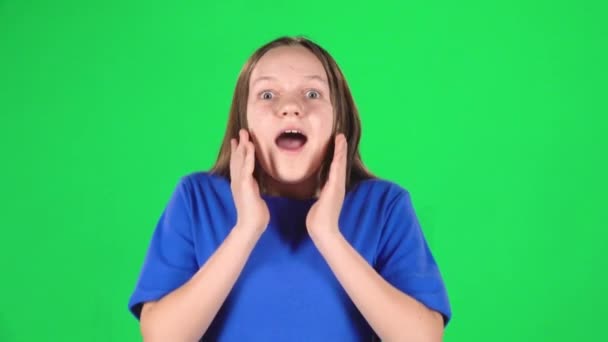 Girl is surprised and very rejoiced in studio on green screen. Slow motion — Stock Video