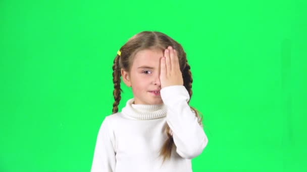 Το μικρό θηλυκό κρύβει το πρόσωπο με τα χέρια στην πράσινη οθόνη. Αργή κίνηση — Αρχείο Βίντεο