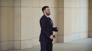 Yakışıklı bin yıllık işadamı kutluyor ve aptal goofy doğrudan kameraya onun başarı ve başarı kutluyor dans