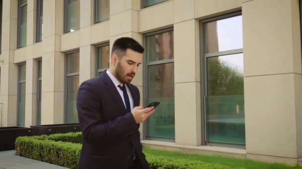 Επιχειρηματίας παίρνει άσχημα νέα από το smartphone συνομιλία σε ένα δρόμο για το γραφείο και να θυμώσει εξαιτίας του. — Αρχείο Βίντεο