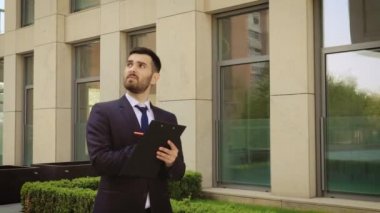 Genç işadamı elinde bir tabletle sokakta yürüyor. Yakın çekim.