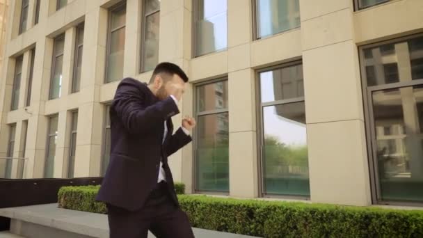 Empresário de sucesso feliz dançando no fundo de um edifício moderno — Vídeo de Stock